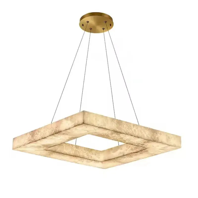 Modern pendant light with gold fixture and marble-like shade on a white background