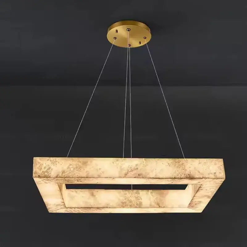 Modern pendant light with gold fixture and rectangular beige shade on a black background