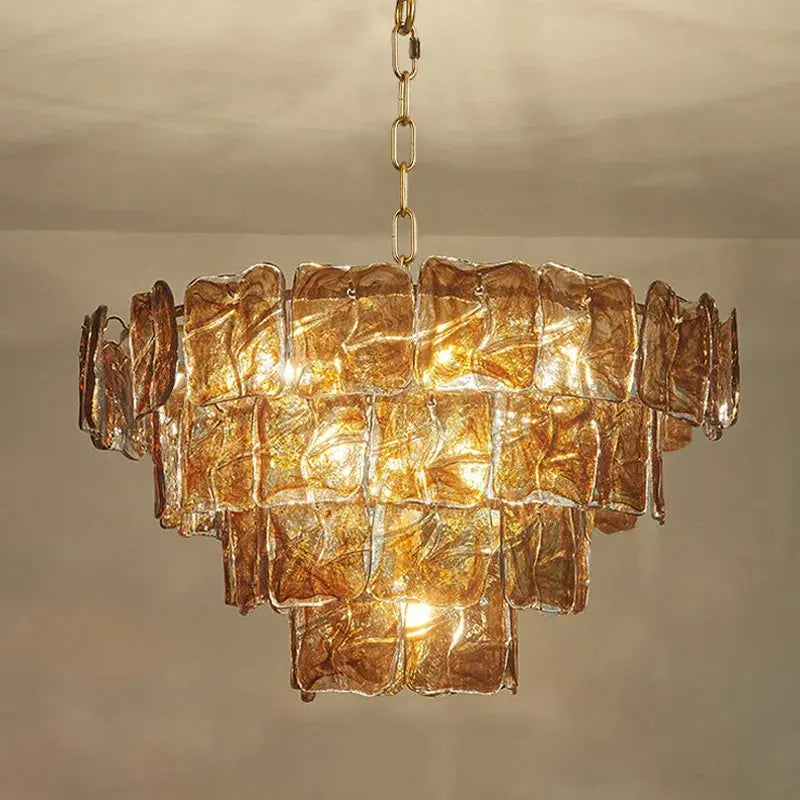 Gold chandelier with textured glass panels on a neutral background