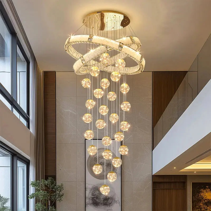 Modern chandelier hanging in a stylish interior setting with large windows and architectural elements.