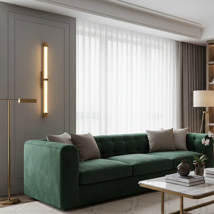 Modern wall-mounted light fixture on a gray wall with a plant in the foreground