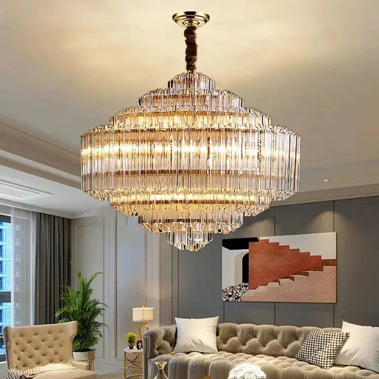 Luxurious living room with a large crystal chandelier, gray sofa, and decorative items.
