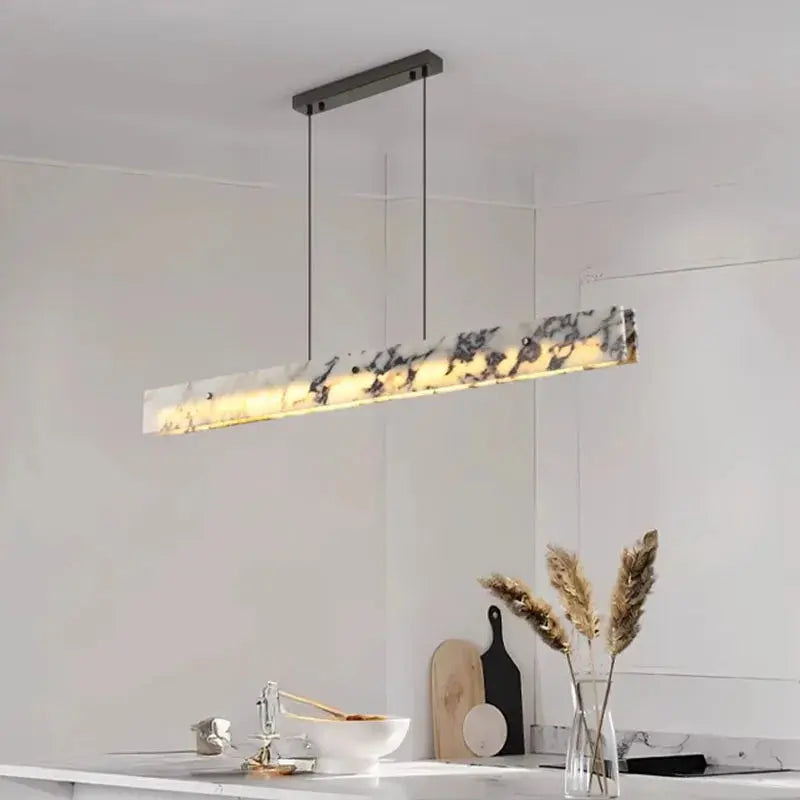 Modern pendant light fixture in a kitchen setting with a neutral background