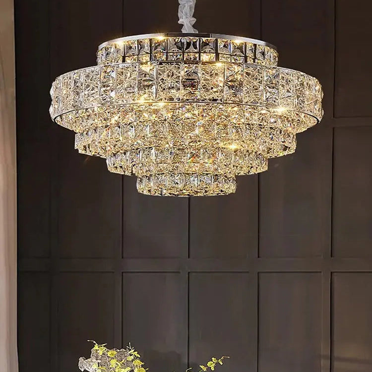 Luxurious chandelier hanging above a table with decorative elements against a dark paneled wall.